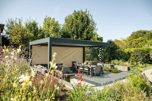 Louvered pergola in a picturesque garden on a sunny day