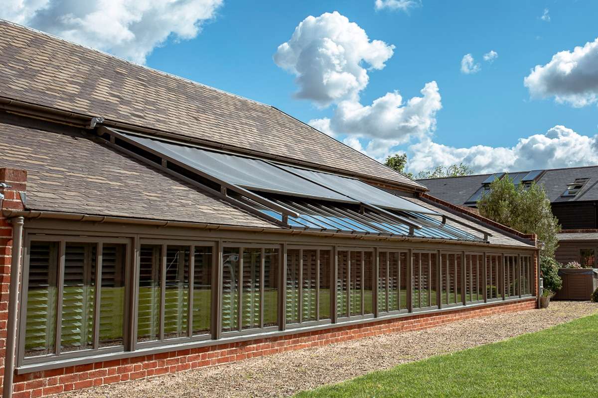 external blinds on a glass roof - bright an blue sky is in the background.