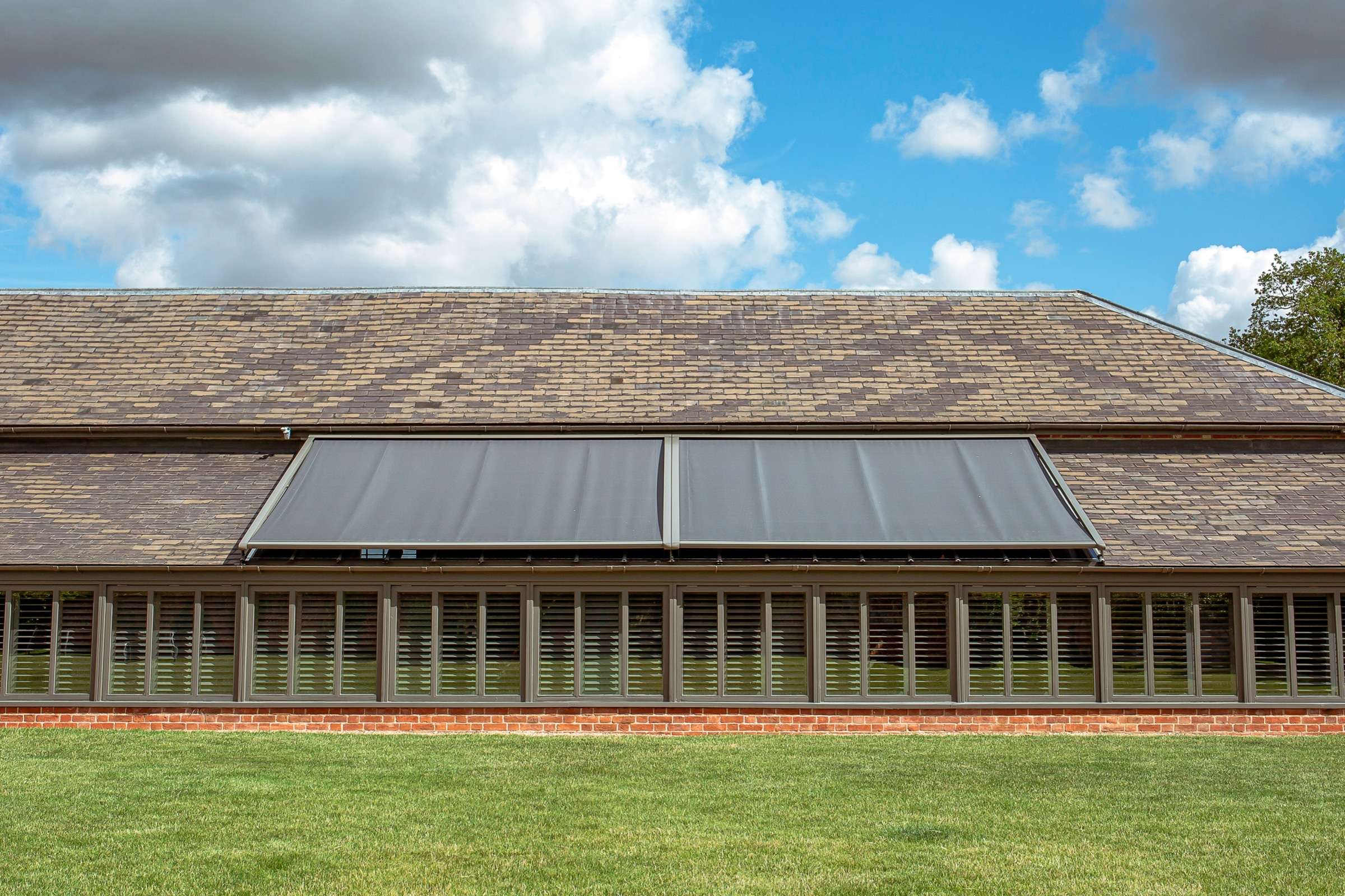 external blinds on a glass roof - bright an blue sky is in the background.