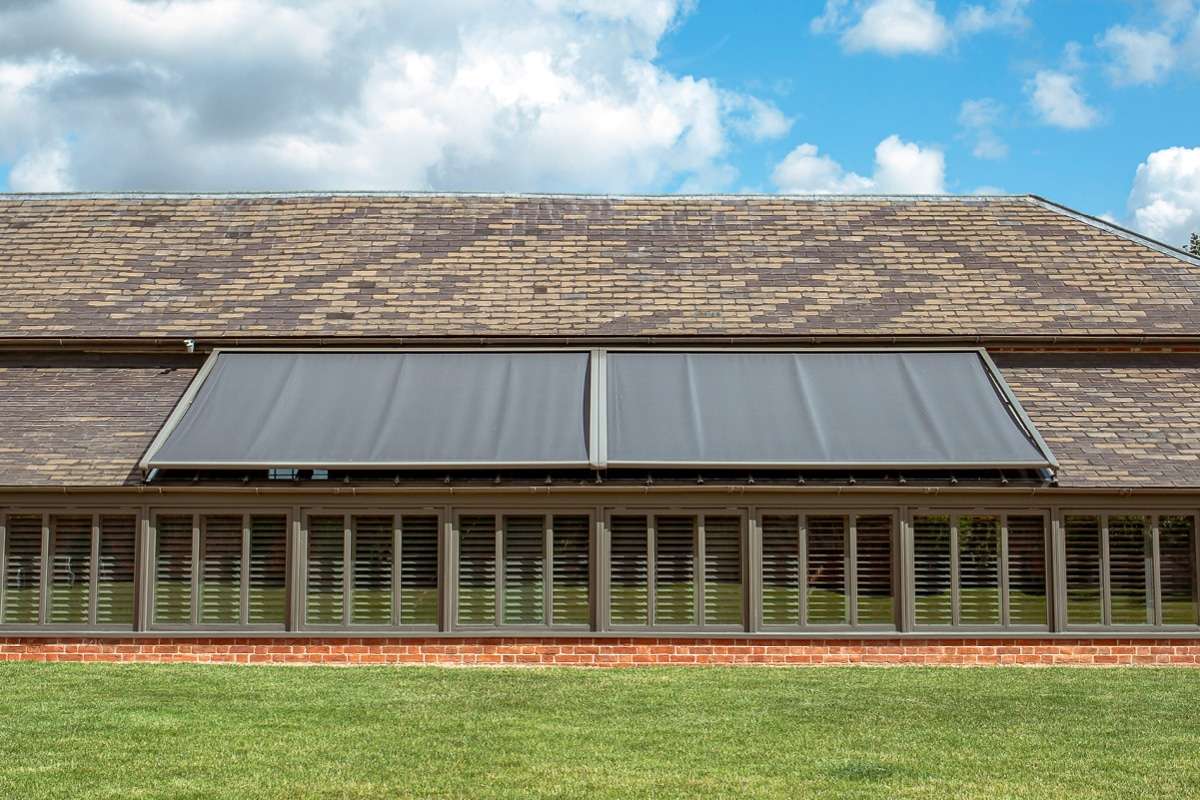 external blinds on a glass roof - bright an blue sky is in the background.