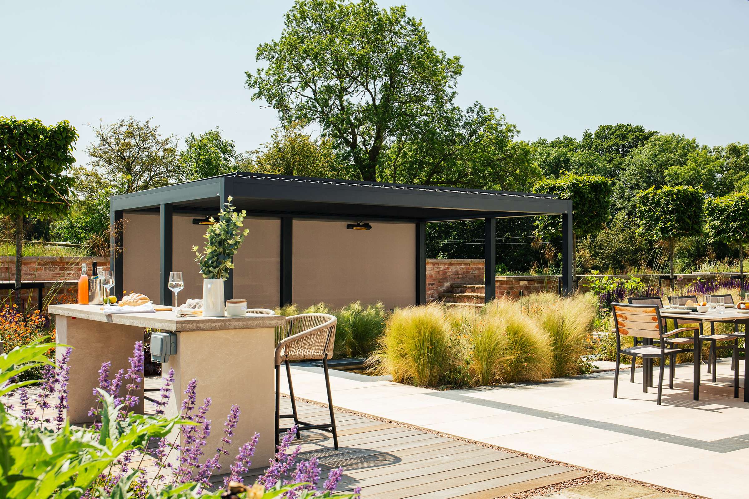 A pergola on a patio surrounded by trees on a sunny day,